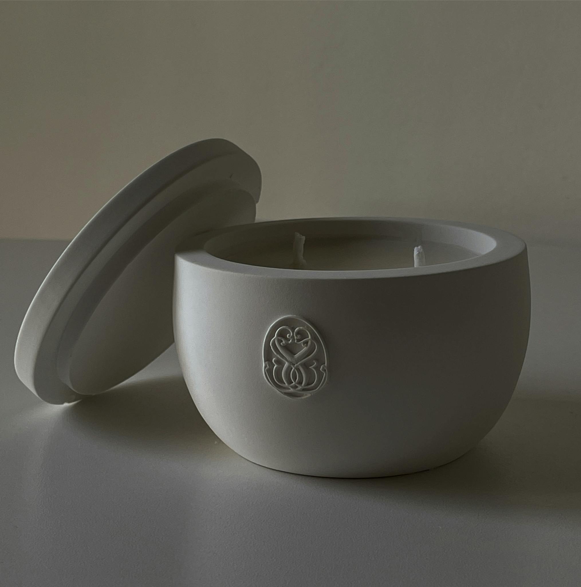 Minimalist white ceramic candle holder with lid, perfect for home decor.
